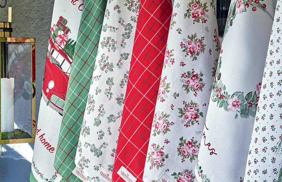 Eine Reihe Weihnachtshandtücher, die an einem Gestell hängen.