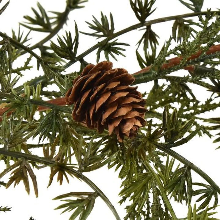 Eine Nahaufnahme der Alsaba Home Künstliche Tannengirlande mit Zapfen naturgetreu 180 cm zeigt einen realistischen braunen Tannenzapfen auf einem grünen, nadelartigen Zweig vor einem weißen Hintergrund.