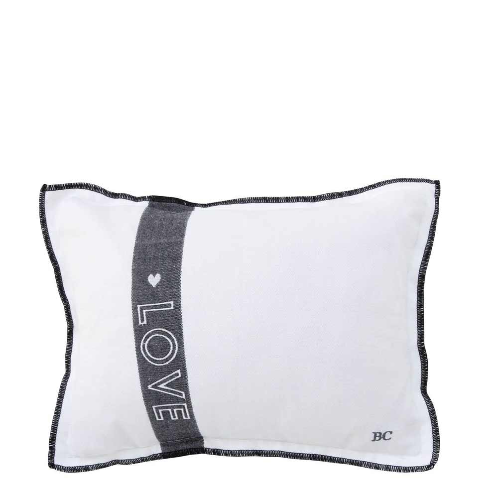 Weißes rechteckiges Bastion Collection - Kissen Love 25 x 35 cm mit Füllung mit schwarzer Paspel, verziert mit einem vertikalen schwarzen Streifen mit dem Wort „LOVE“ und einem kleinen Herz. Die Initialen „BC“ befinden sich in der unteren rechten Ecke.