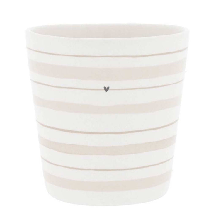 Bastion Collections - Becher Watercolour Streifen Natur: Eine weiße Tasse mit horizontalen beigen Streifen und einem kleinen schwarzen Herz in der Mitte.