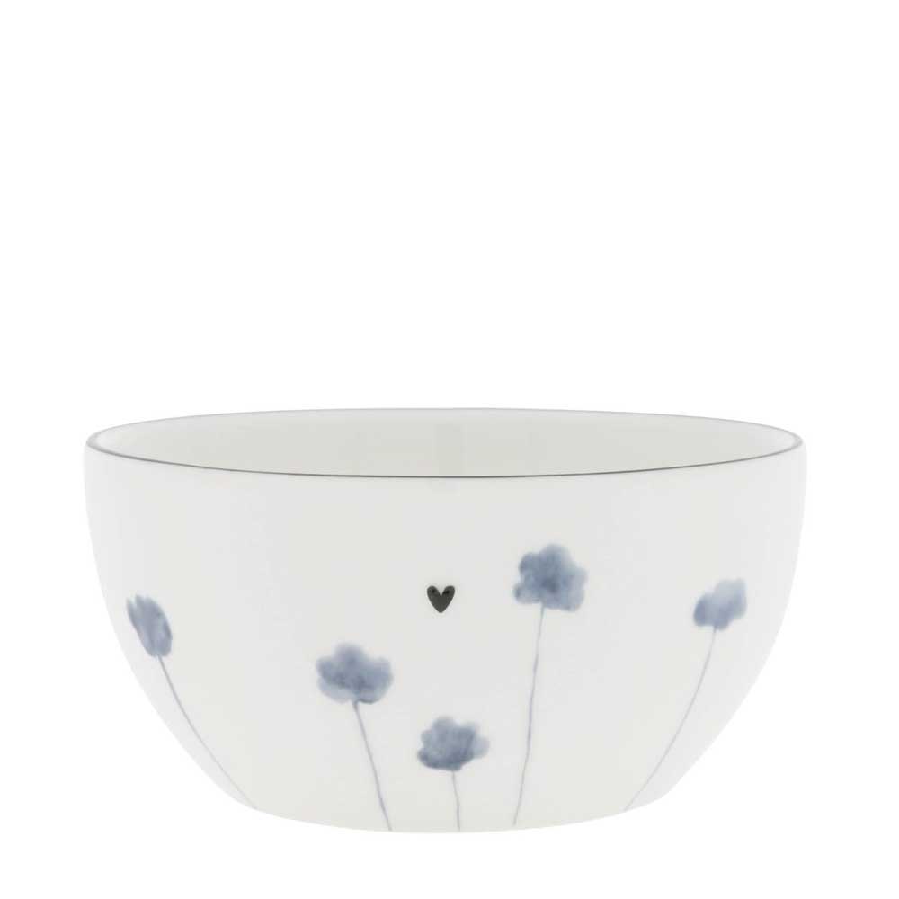 Die Schüssel Iris Blue Poppy der Bastion Collections ist eine weiße Keramikschüssel mit minimalistischem Design, die blaugraue Blumenmuster und ein kleines schwarzes Herz zeigt.