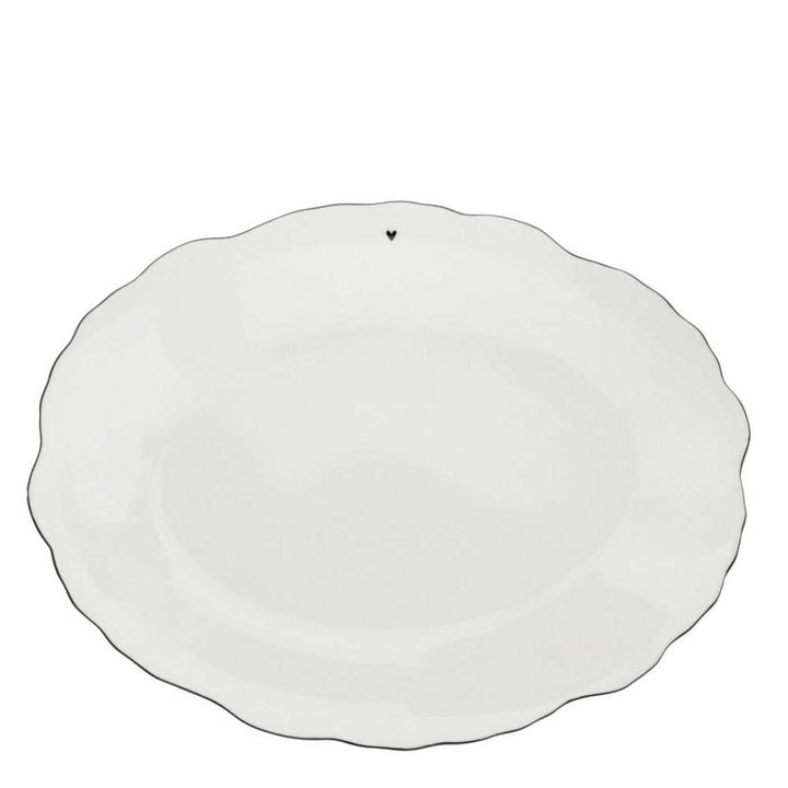 Bastion Collections – Servierplatte White Flower: Ein weißer Keramikteller mit gewelltem Rand und einem kleinen Herz am Rand.