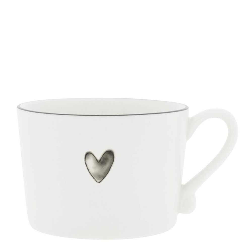 Die Bastion Collections - Tasse Watercolour schwarzes Herz ist eine weiße Keramiktasse mit einem kleinen Herzdesign in der Mitte und präsentiert sich in einem schlichten und minimalistischen Stil.