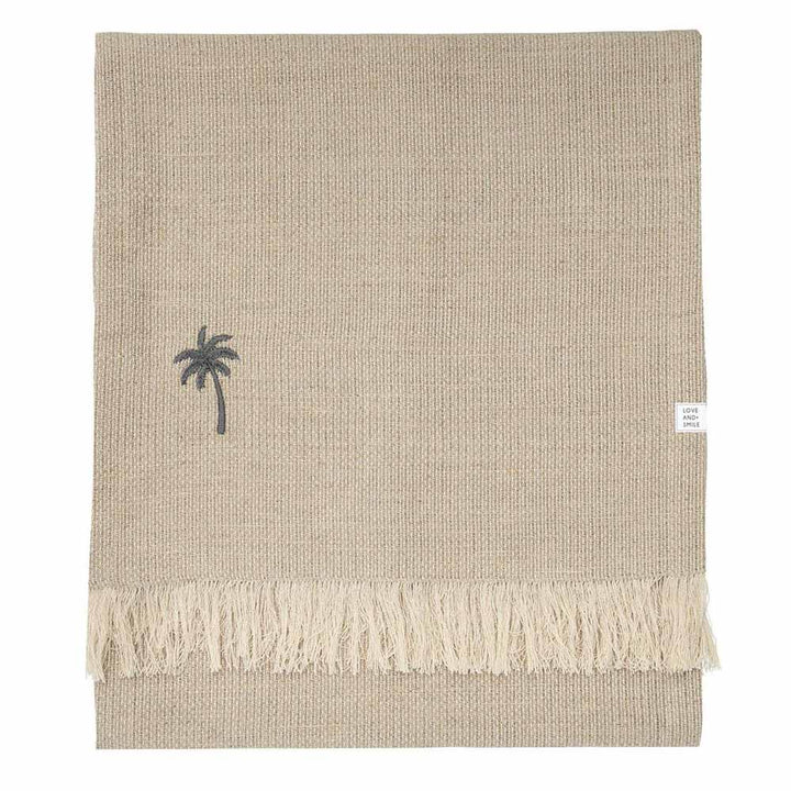 Beiger Tischläufer aus Leinen von Bastion Collections mit den Maßen 160 x 38 cm mit Fransenkanten und einer kleinen gestickten Palme.