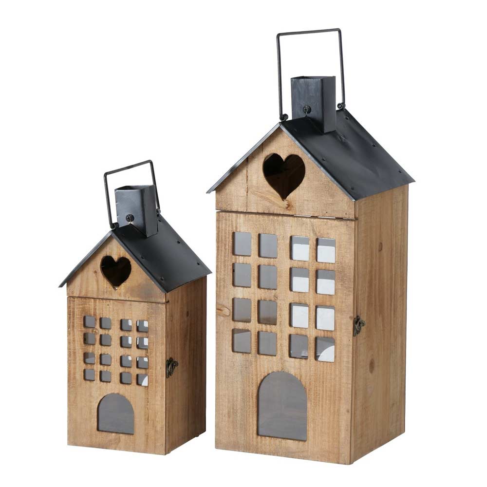 Das Set „Boltze - Laterne Brixen Haus“ besteht aus zwei hölzernen Laternen in Hausform mit Metalldächern und herzförmigen Ausschnitten an der Spitze. Die Laternen sind mit Glasfenstern versehen und verfügen über Tragegriffe. Das Set enthält eine größere Laterne und eine kleinere.