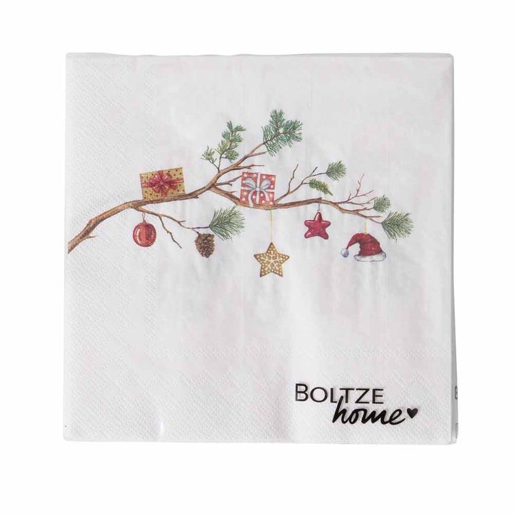 Die Papierserviette „Weihnacht mit Tannenzweig“ ist eine weihnachtlich gestaltete Serviette mit einem Zweig, der mit Ornamenten wie einer Geschenkbox, einem Stern, einem Tannenzapfen, einer roten Kugel und einer Weihnachtsmannmütze verziert ist. Unten ist der Text „Boltze Home“ zu sehen.
