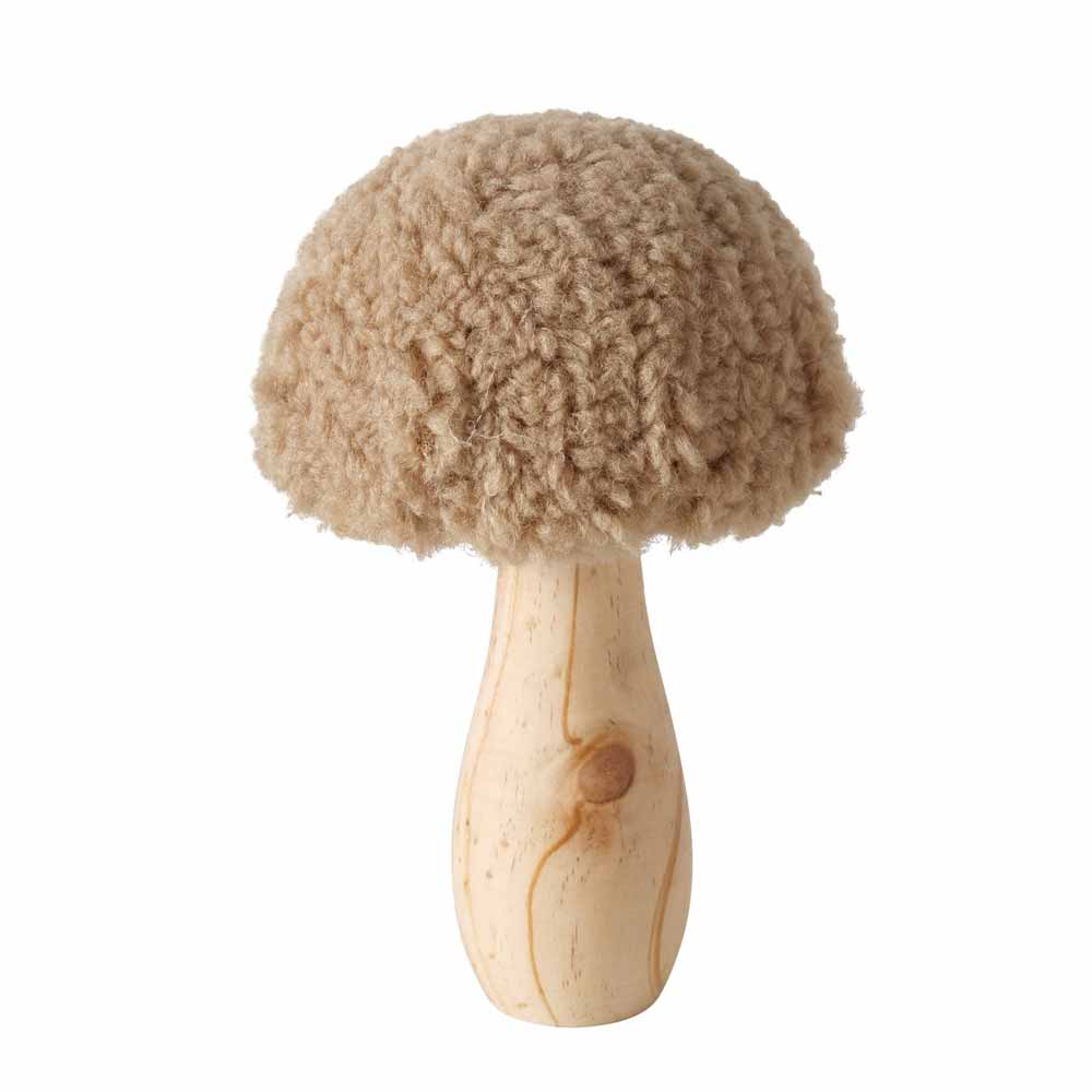 Ein Boltze - Pilz Deko-Teddy mit einem Holzsockel und einer gelockten Wollspitze, die an einen Pilzhut erinnert.