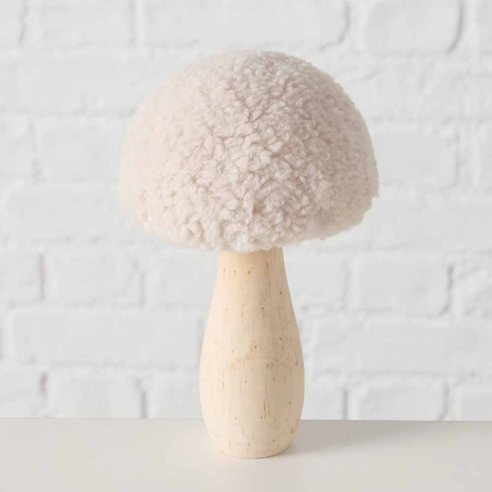 Der Boltze - Pilz Deko Teddy, ein strukturierter beiger Pilz mit flauschigem Hut und glattem Stiel, wird vor einer weißen Backsteinwand präsentiert.