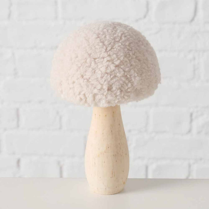 Der Boltze - Pilz Deko Teddy, ein strukturierter beiger Pilz mit flauschigem Hut und glattem Stiel, wird vor einer weißen Backsteinwand präsentiert.