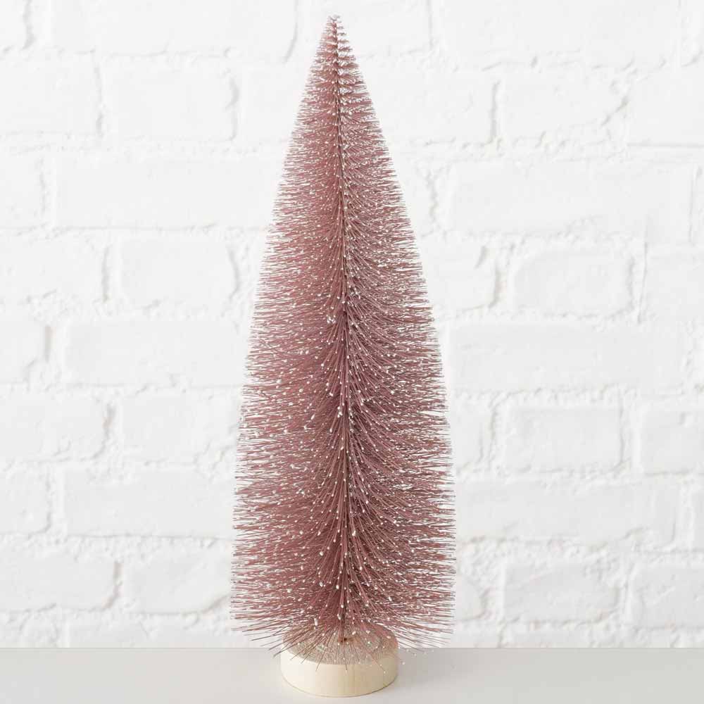 Boltze - Weihnachtsbaum Vintage Pastell auf einem Holzsockel vor einem weißen Backsteinmauerhintergrund.