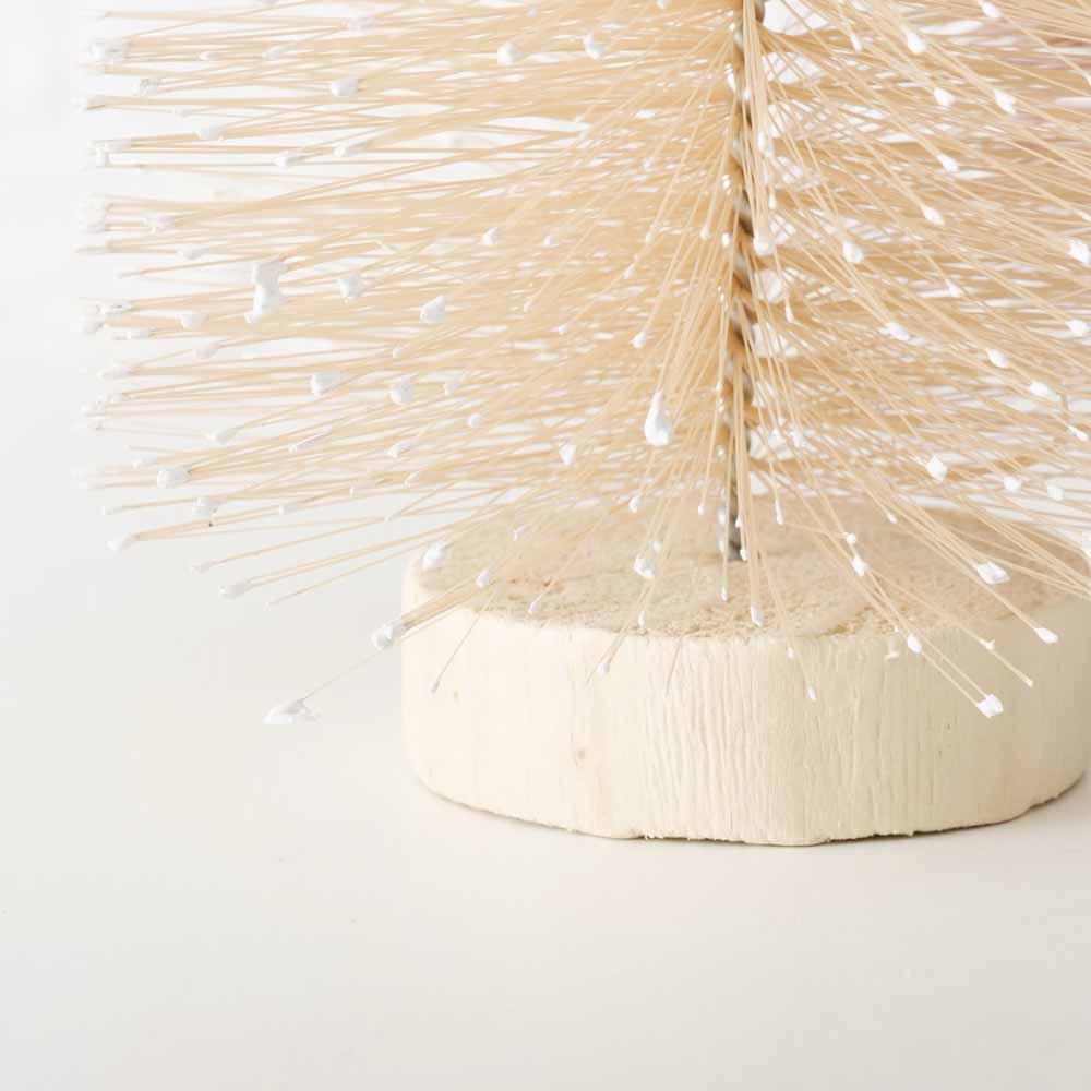 Eine Nahaufnahme des beigen Weihnachtsbaums von Boltze mit einem Vintage-Pastelldesign auf einem Holzsockel mit kleinen weißen Zierspitzen und einer Höhe von 40 cm.