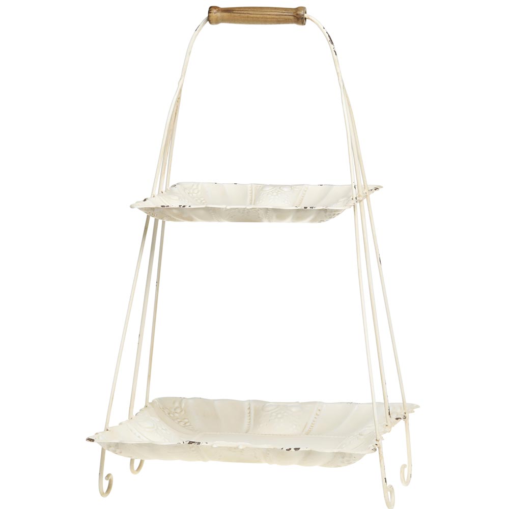Ein zweistöckiges Serviertablett aus Metall mit einem Finish in Antikweiß und einem Holzgriff an der Oberseite. Die Chic Antique - Etagere mit Henkel hat ein Vintage-Design und wird von geschwungenen Metallbeinen getragen.