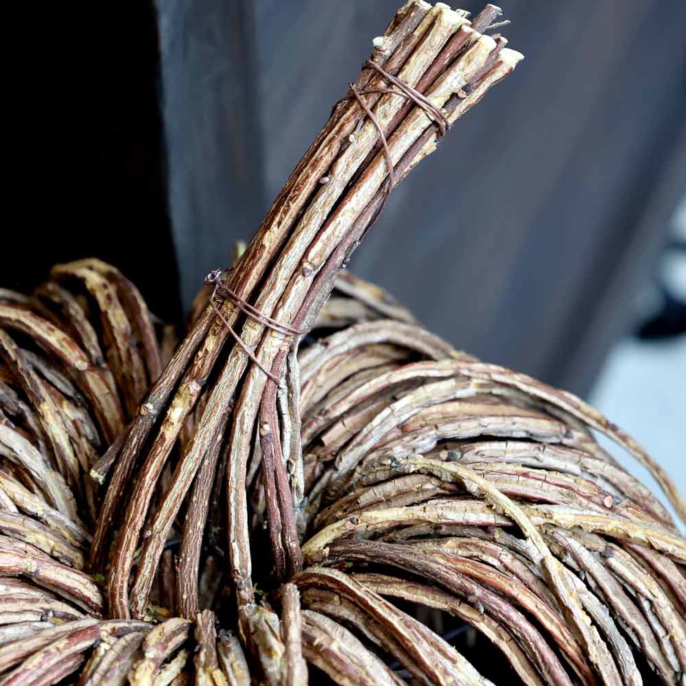 Nahaufnahme von Chic Antique – Kürbis Rattan, einer kürbisförmigen Dekoration aus gebündelten, gewickelten Zweigen mit einem gedrehten Stiel und einer Drahtbindung.