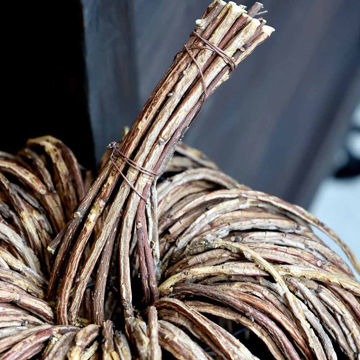 Nahaufnahme von Chic Antique – Kürbis Rattan, einer kürbisförmigen Dekoration aus gebündelten, gewickelten Zweigen mit einem gedrehten Stiel und einer Drahtbindung.