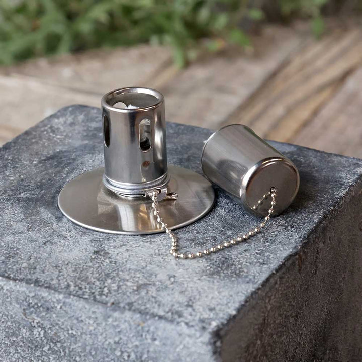 Eine metallische ausziehbare Chic Antique - Öllampe im Zementblock mit Kette, stehend auf einem runden Sockel, ist auf einer Steinfläche platziert. Ein weiterer Teil der Halterung ist abgenommen und liegt daneben.