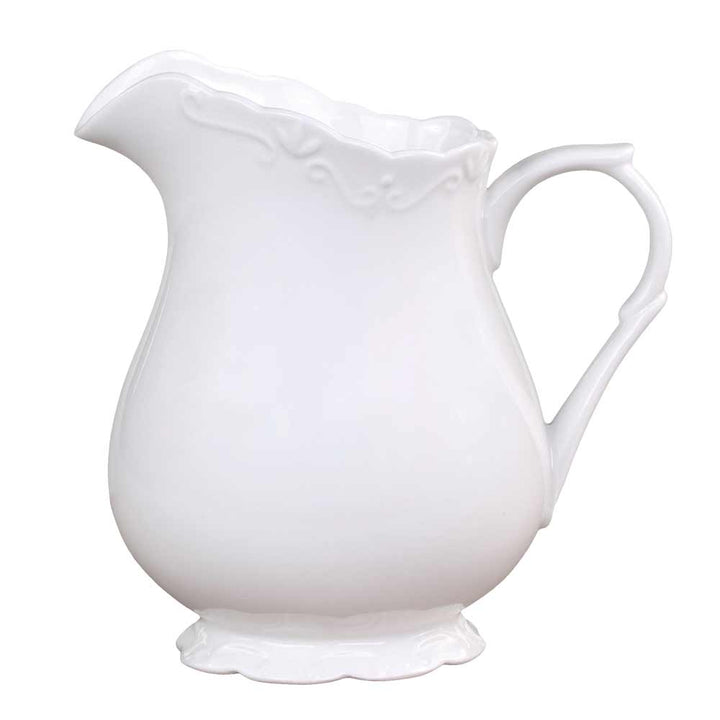 Eine Chic Antique - Provence Kanne 1 Liter mit geschwungenem Henkel und gewelltem Rand sowie dezenten Blumenmustern auf Korpus und Boden.