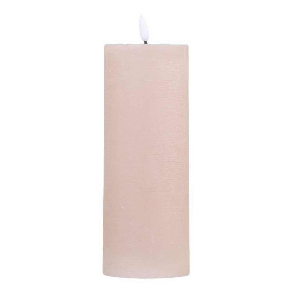 Eine große, zylindrische, beige Chic Antique - Stumpenkerze LED staubig rosa inkl. Batterie mit einer brennenden weißen Flamme.
