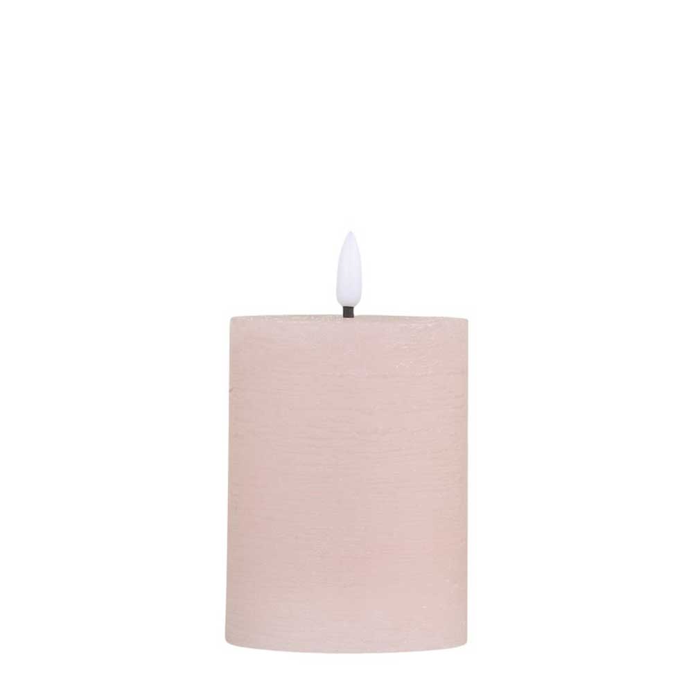 Eine beige zylindrische Kerze mit einem Docht und weißer Flamme wurde durch die Chic Antique - Stumpenkerze LED staubig rosa inkl. Batterie ersetzt.