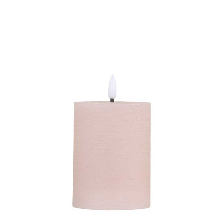 Eine beige zylindrische Kerze mit einem Docht und weißer Flamme wurde durch die Chic Antique - Stumpenkerze LED staubig rosa inkl. Batterie ersetzt.