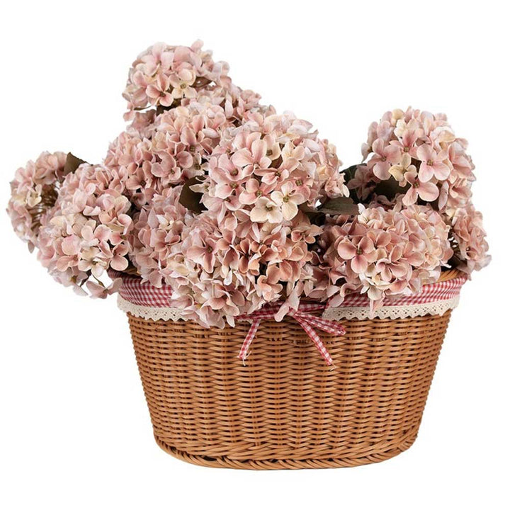 Ein Clayre & Eef Geschenkkorb Picknick Landhaus gefüllt mit hellrosa Hortensienblüten.