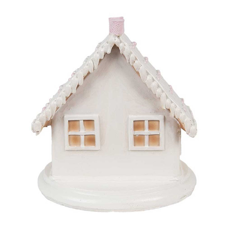 Das „Clayre & Eef – Lebkuchenhaus mit LED 13 cm“ ist eine kleine, weiße Hausfigur aus Keramik mit einem steilen Dach, zwei quadratischen Fenstern und einem runden Sockel.