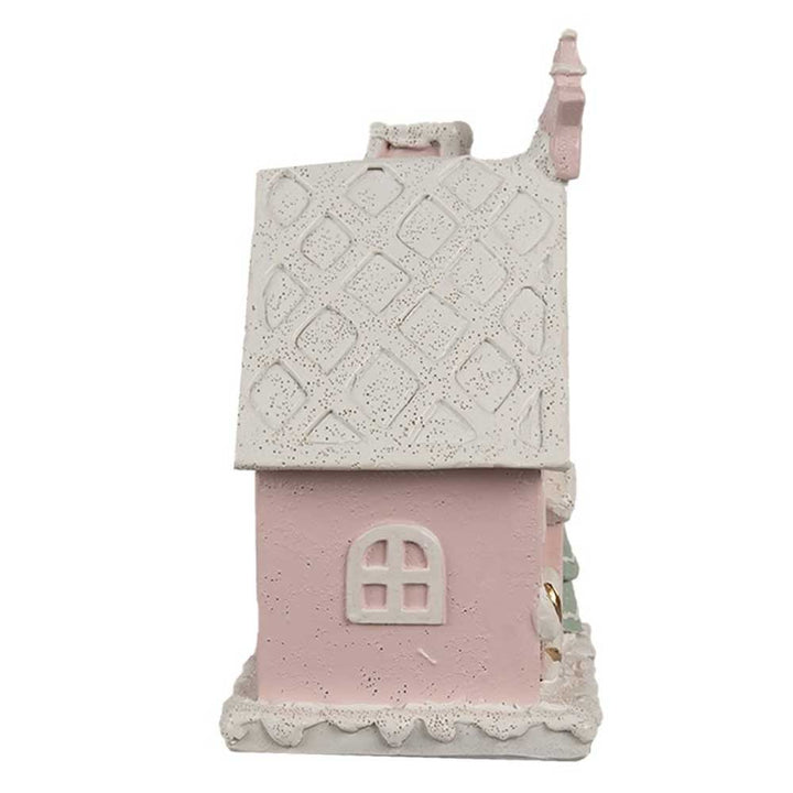 Seitenansicht des Clayre & Eef – Lebkuchenhaus mit LED 15 cm Rosa, bestehend aus einem kleinen rosa Deko-Haus mit weißem strukturiertem Dach und Bogenfenster.