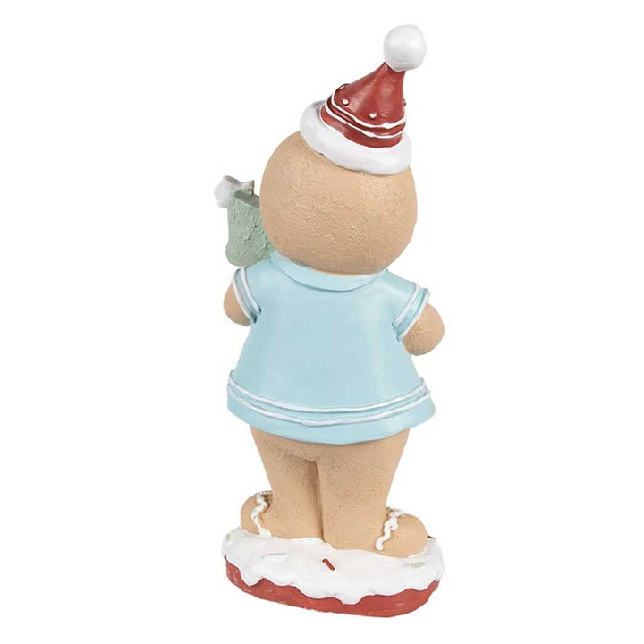 Eine Keramikfigur namens „Clayre & Eef – Lebkuchenmann mit Weihnachtsbaum“, die einen Lebkuchenmann in einem hellblauen Outfit mit einer roten Weihnachtsmannmütze zeigt, der ein grünes Geschenk hält und auf einem schneebedeckten Sockel steht.