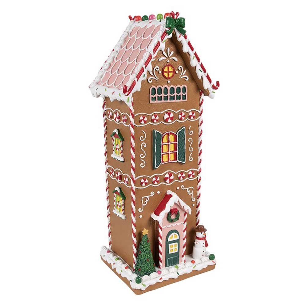 Das Clayre & Eef - Lebkuchenhaus Mega 40 cm verfügt über ein großes Lebkuchenhaus-Design mit roten und weißen Zuckerguss-Details, geschmückt mit grünen Kränzen, Pfefferminzbonbons und einem kleinen Schneemann am Eingang.