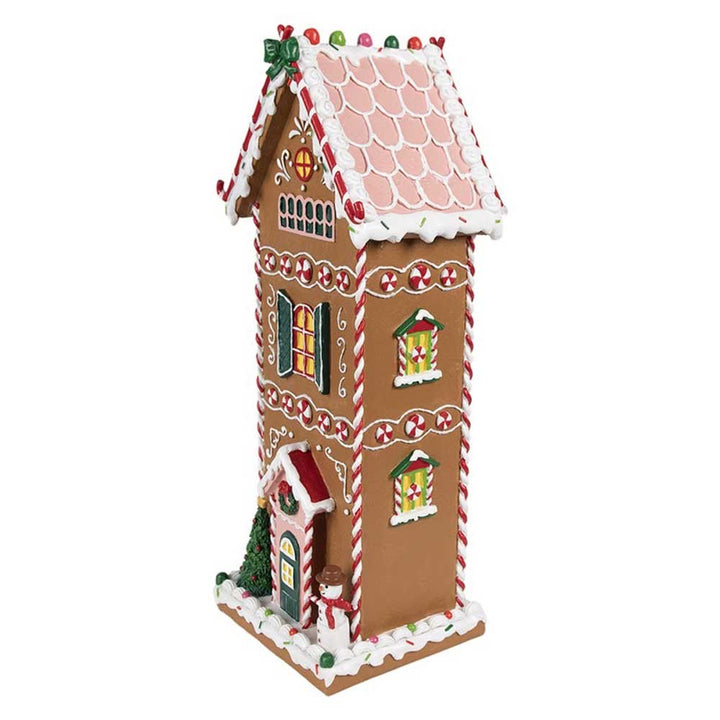 Das Clayre & Eef - Lebkuchenhaus Mega 40 cm verfügt über eine hohe Struktur, die mit bunten Süßigkeiten-Dekorationen und Akzenten aus weißem Zuckerguss geschmückt ist.