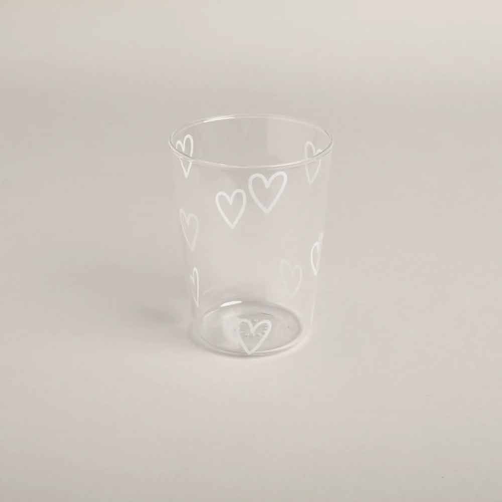 Das Eulenschnitt - Trinkglas Herzen weiß ist ein Klarglasbecher mit weißen herzförmigen Mustern auf einem schlichten, hellen Hintergrund.