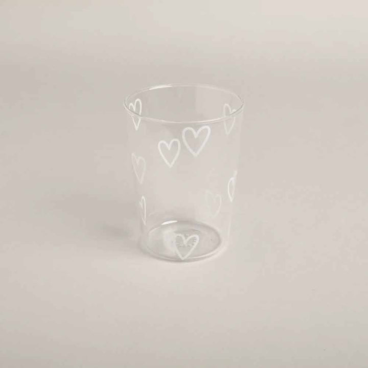 Das Eulenschnitt - Trinkglas Herzen weiß ist ein Klarglasbecher mit weißen herzförmigen Mustern auf einem schlichten, hellen Hintergrund.