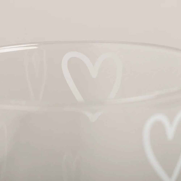 Das Eulenschnitt - Trinkglas Herzen weiß ist ein klarer Glasbecher mit weißen Herzumrissen vor einem neutralen Hintergrund.