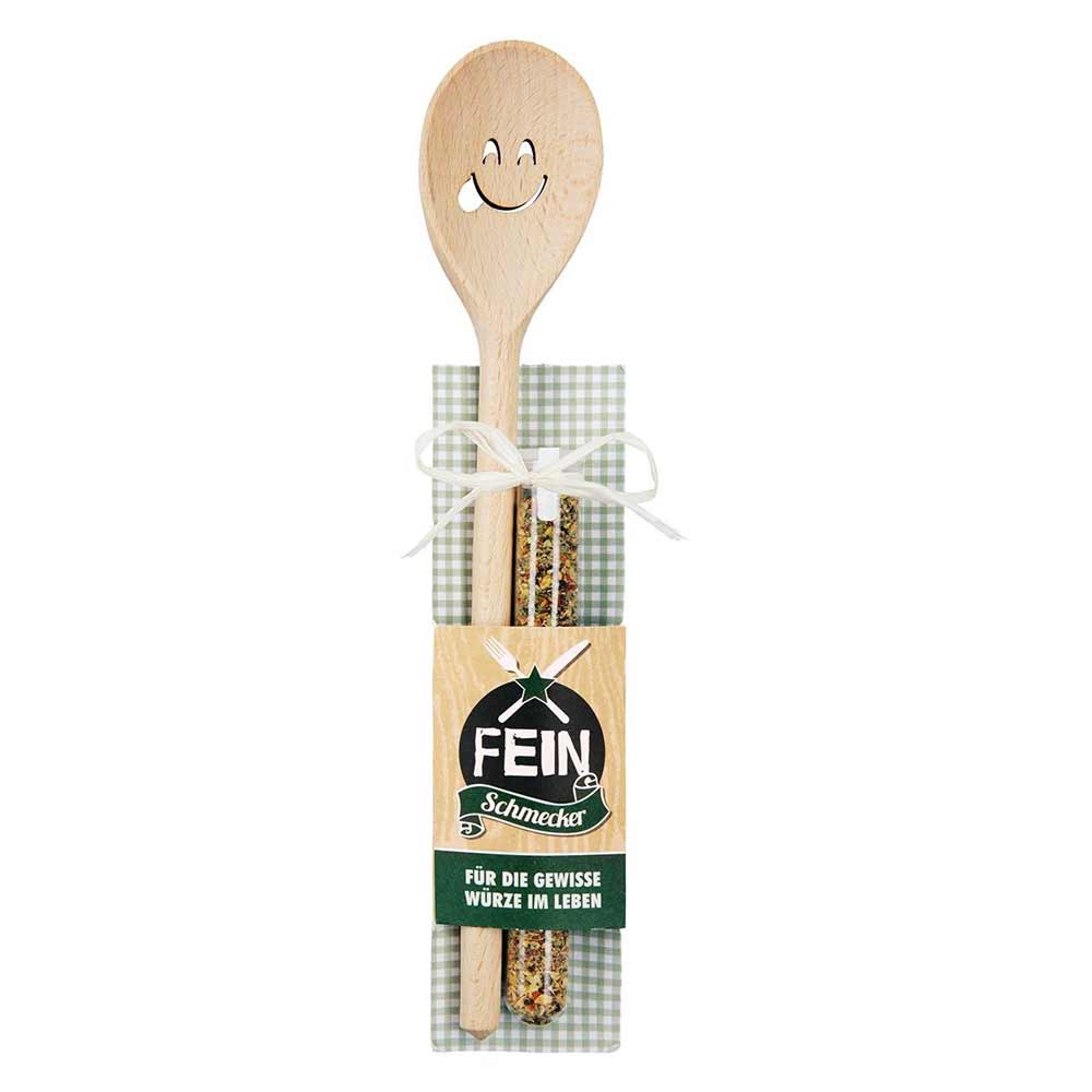 Das Gilde Geschenkset besteht aus einem Kochlöffel aus Holz mit Smiley und zwei Gewürzröhrchen, verpackt auf grün-weiß kariertem Untergrund mit Schleife und der Aufschrift „FEINSCHMECKER“.