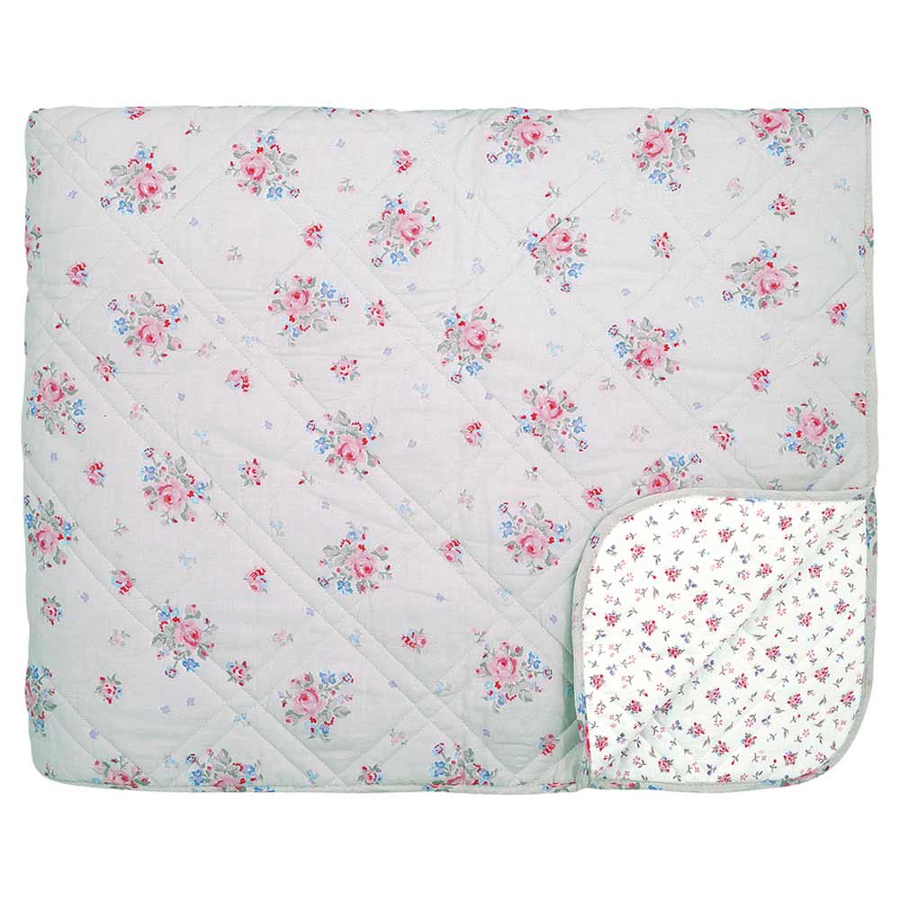 Abgebildet ist ein GreenGate - Elysia Quilt in Hellgrau 140x220 cm mit einem roten und blauen Blumenmuster. Der Quilt ist an einer Ecke nach hinten gefaltet, so dass ein weißes Futter mit einem kleineren Blumendruck zum Vorschein kommt.