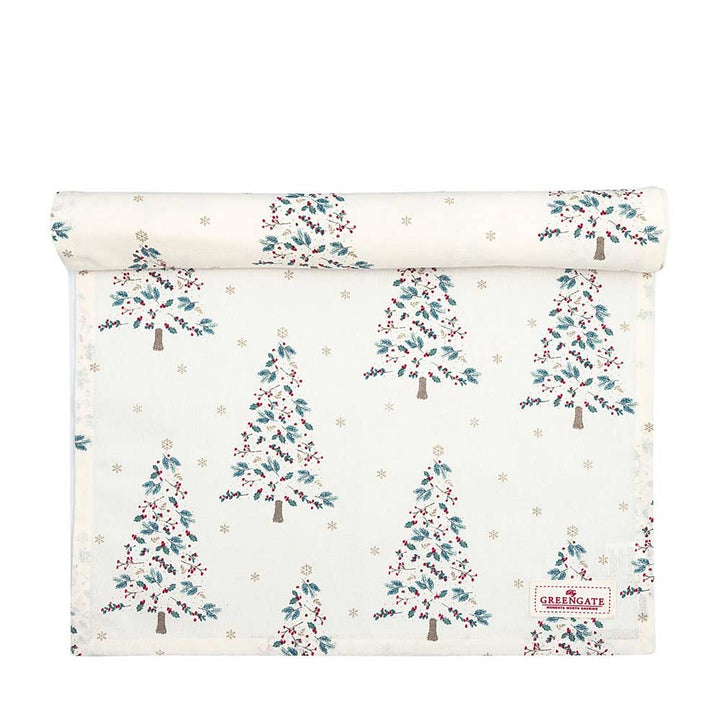 Eine aufgerollte Tischdecke namens „GreenGate – Lucie Tischläufer xmas white“, verziert mit Weihnachtsbaummustern in Grün, Rot und Blau sowie kleinen Sternen.