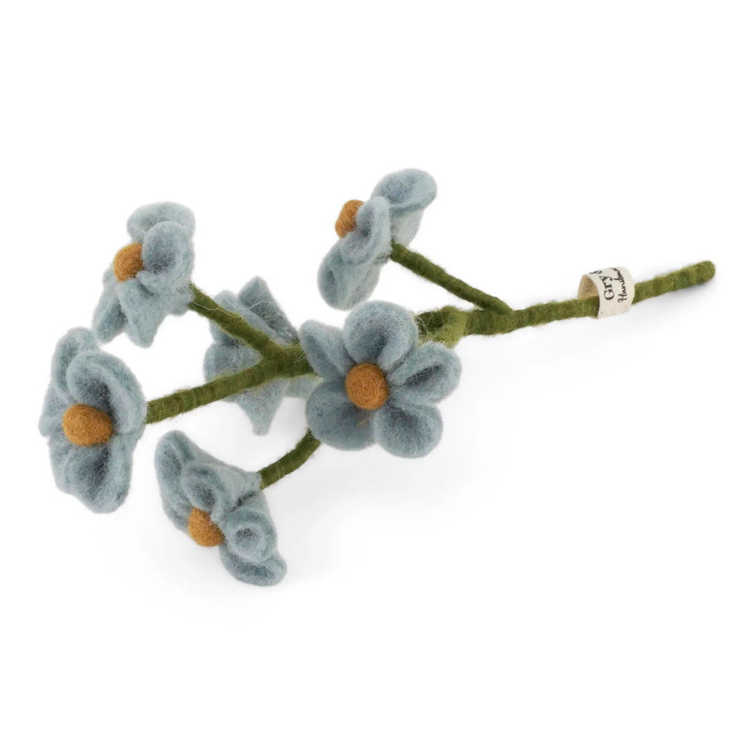 Die Gry & Sif - Vergiss mein nicht Filzblume zeigt fünf blaue Filzblüten mit gelber Mitte auf einem grünen Filzstiel, komplett mit einem kleinen Etikett.