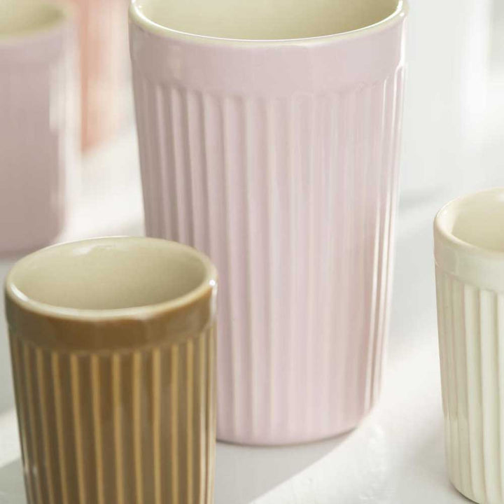 Drei Ib Laursen - Cafe Latte Becher mit Rillen Mynte in verschiedenen Größen und Farben (Rosa, Hellbraun und Weiß) auf einer hellen Oberfläche.