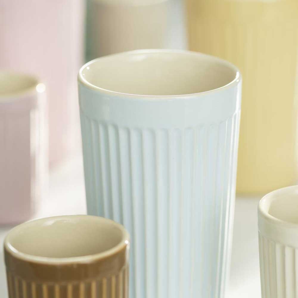 Nahaufnahme der farbenfrohen Ib Laursen-Café-Latte-Becher mit Rillen Mynte mit vertikalen Rillen, mit Fokus auf einer hellblauen Tasse im Vordergrund.