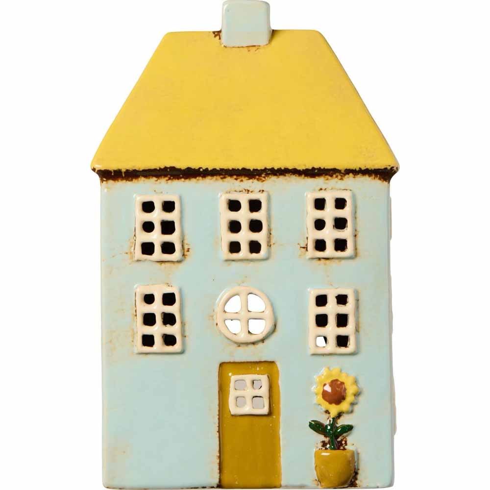 Das Ib Laursen Haus für Teelicht Nyhavn hat ein gelbes Dach, hellblaue Wände, weiße Fenster und eine Sonnenblume in einem Topf neben der gelben Tür.