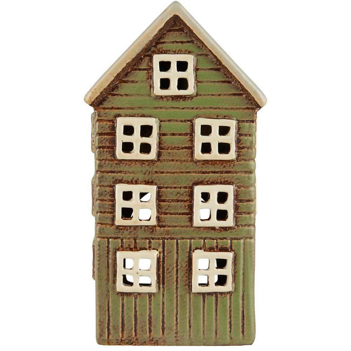 Ein kleines, handgefertigtes Keramikhaus von Ib Laursen namens „Haus für Teelicht Thorshavn“ mit einer grünen, holzstrukturierten Außenseite, mehreren quadratischen Fenstern und einer roten Tür an der Seite.
