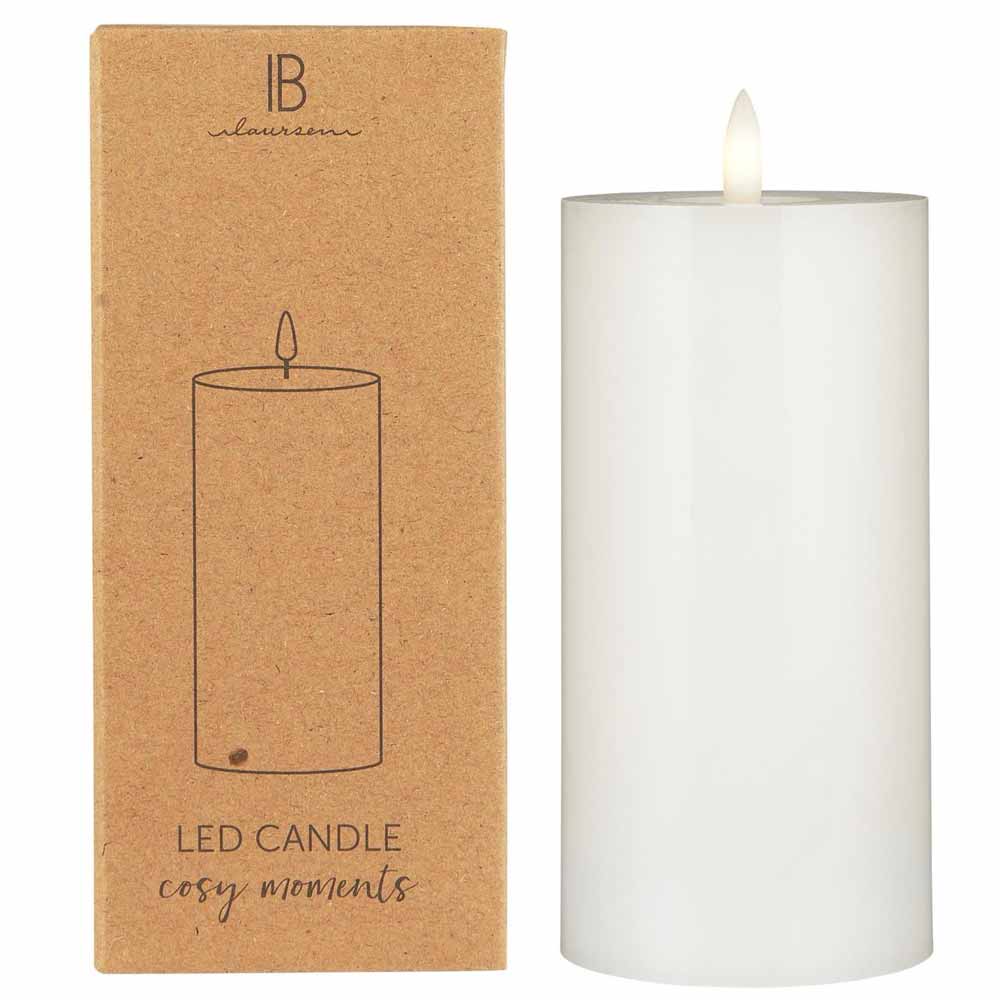 Neben einer braunen Verpackung mit der Aufschrift „Ib Laursen – LED Stumpenkerze mit warmer Flamme“ steht eine weiße LED-Kerze, die einen einfachen Umriss der Kerze zeigt.