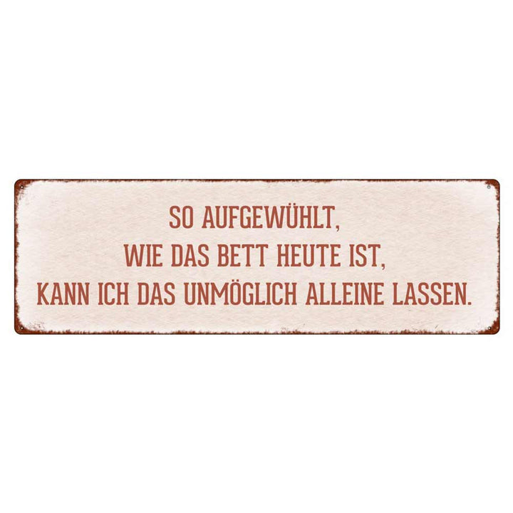 Auf einem rechteckigen Schild mit weißem Hintergrund und rostigen Kanten steht auf Deutsch: „Interluxe Metallschild – So aufgewühlt wie das Bett.“