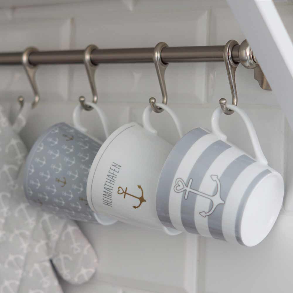 Drei Krasilnikoff - Happy Cup Anker graue Streifen hängen an Haken an einer Metallstange.