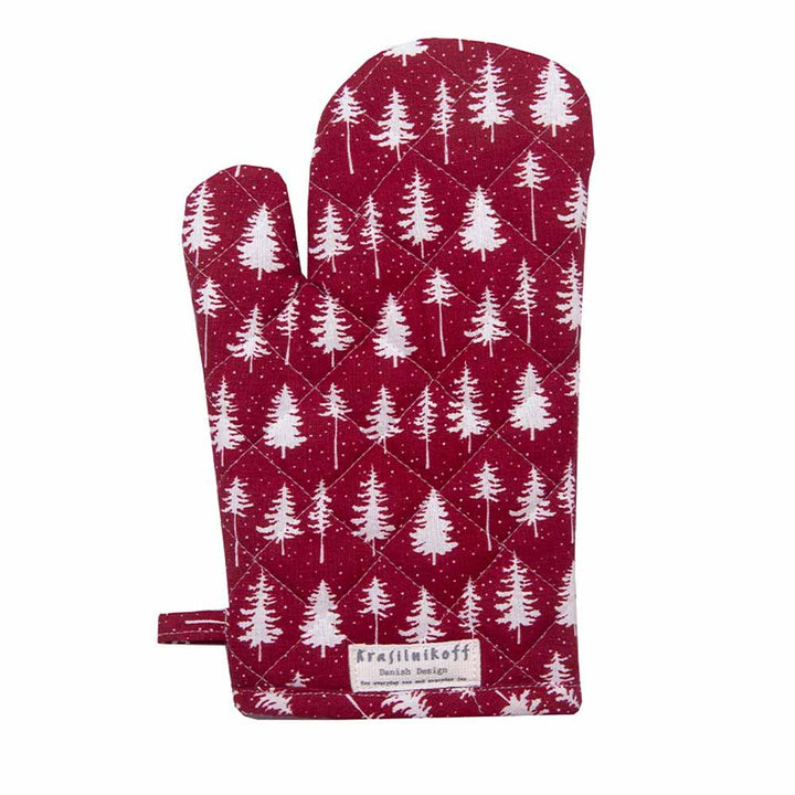 Der Ofenhandschuh „Christmas Forest“ von Krasilnikoff ist in einem kräftigen Rot gehalten, mit einem weißen Baummuster verziert und verfügt an der Unterseite über ein Etikett.