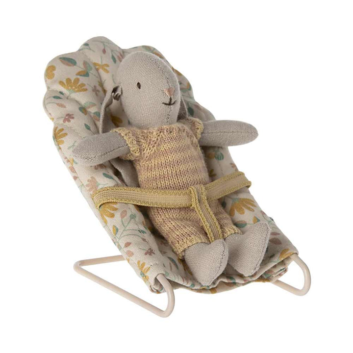 Ein kleiner Stoffhase im gelben Strickoutfit sitzt auf einem Maileg - Babysitter Mikro mit gelbem Riemen.