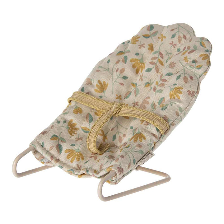 Kleiner Babystuhl aus Stoff mit Blumenmuster und Metallrahmen. Der Maileg - Babysitter Mikro verfügt über einen gelben Stoffgurt zur Sicherung des Kindes.