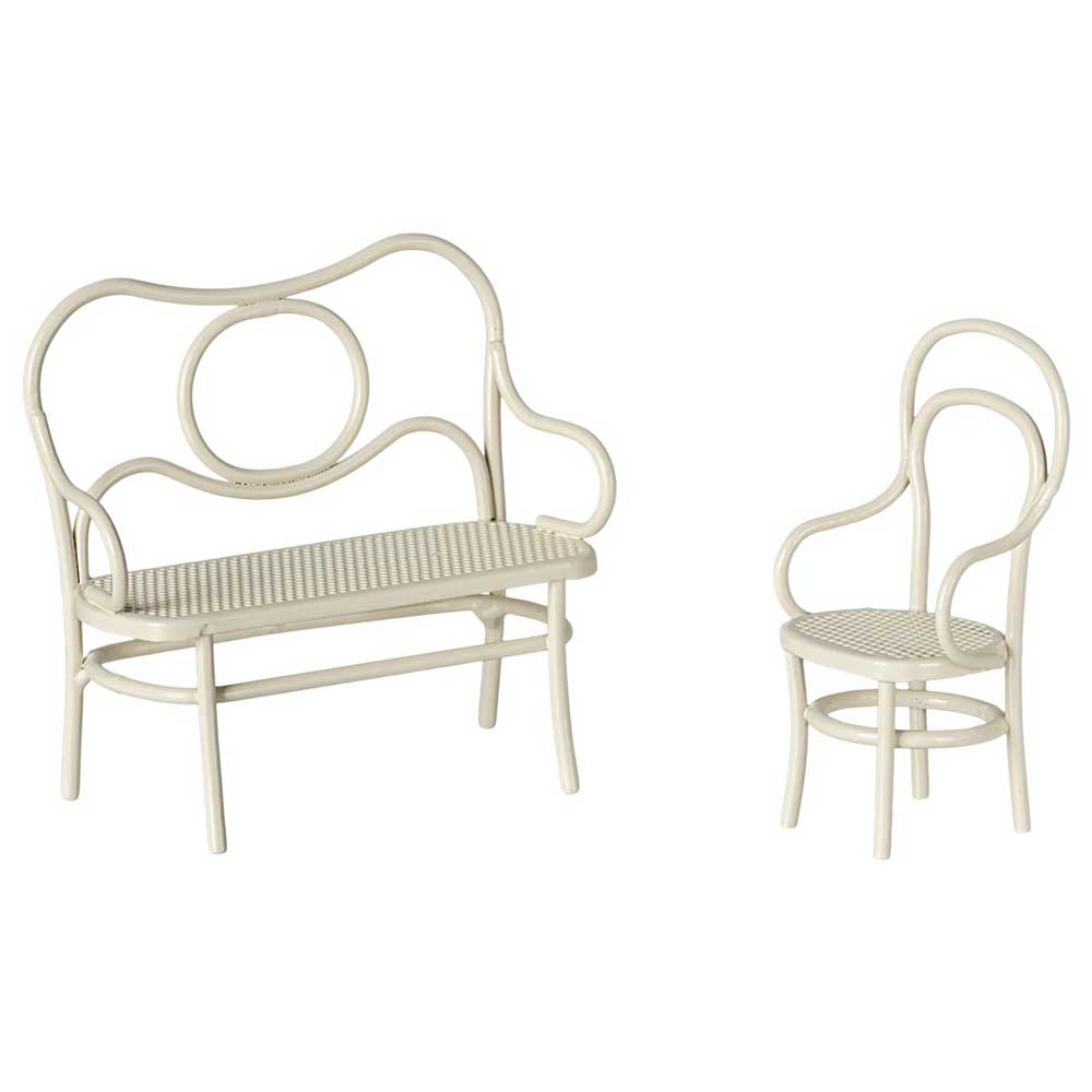 Das Café-Set von Maileg umfasst eine cremefarbene Bank im Vintage-Stil mit runder Rückenlehne und einen dazu passenden Stuhl mit einer kunstvoll geschwungenen Rückenlehne, beide mit Korbsitzfläche.