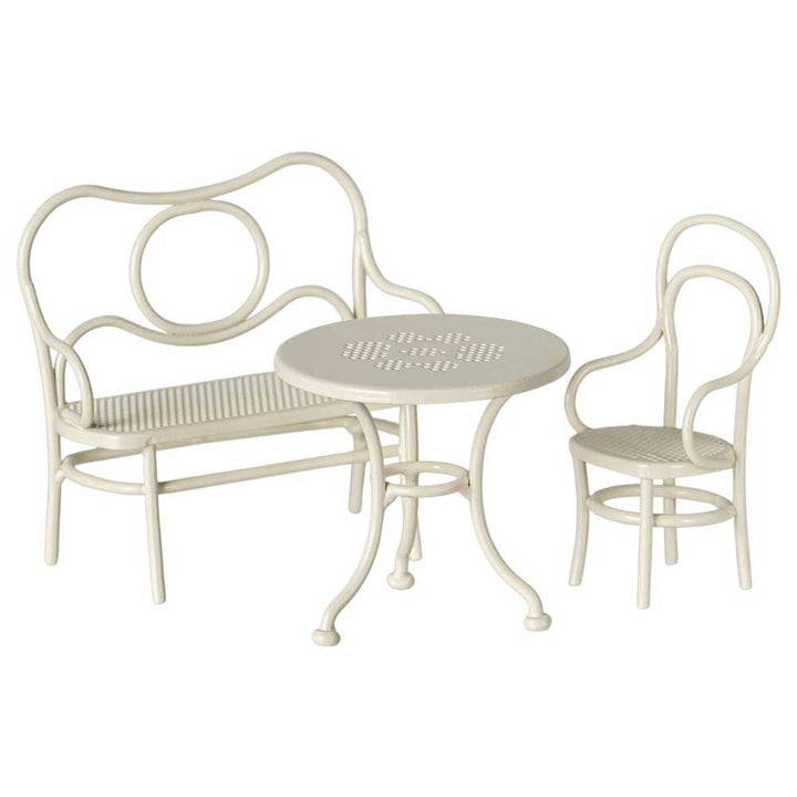 Das Maileg Café-Set umfasst eine cremefarbene Metallbank, einen runden Tisch und einen einzelnen Stuhl.