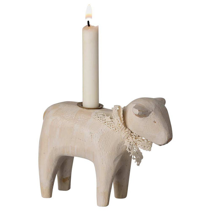 Der Maileg - Kerzenhalter Lamm ist ein hölzerner Kerzenhalter in Schafform mit einer brennenden Kerze auf dem Rücken und einer Spitzenschleife um den Hals.