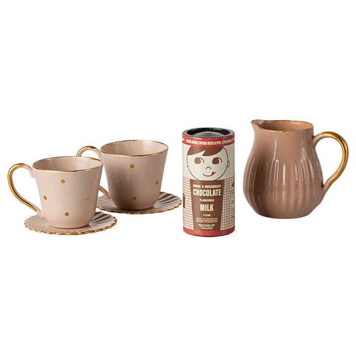 Ein Set aus zwei gepunkteten Teetassen mit Untertassen, einem Behälter mit Schokolade in Vollmilch und einem braunen Krug aus dem Maileg Miniatur Heiße Schokolade Set.
